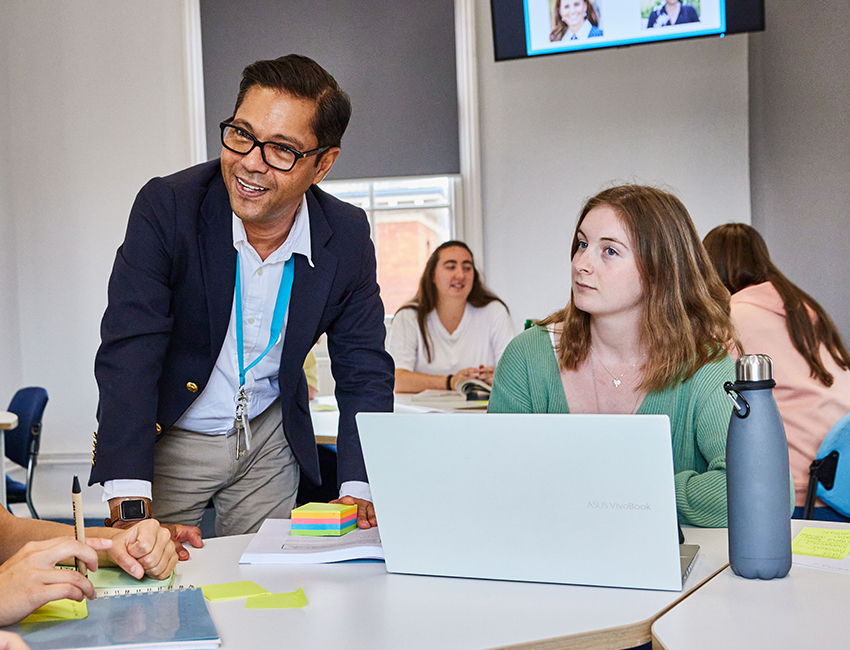A student looking at their lecturer, who is smiling with their students