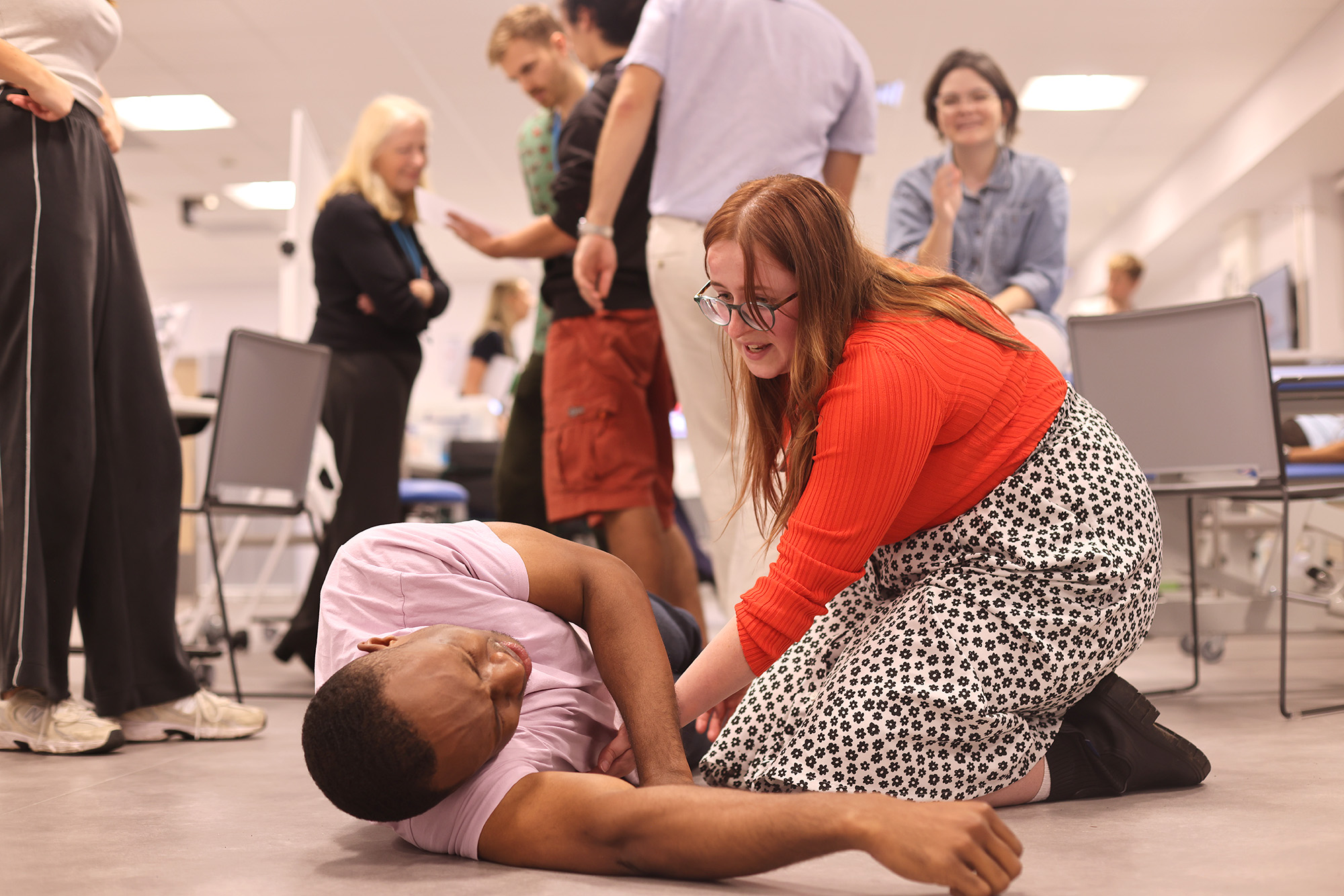 Medical student attending to a patient on the floor at simulation event