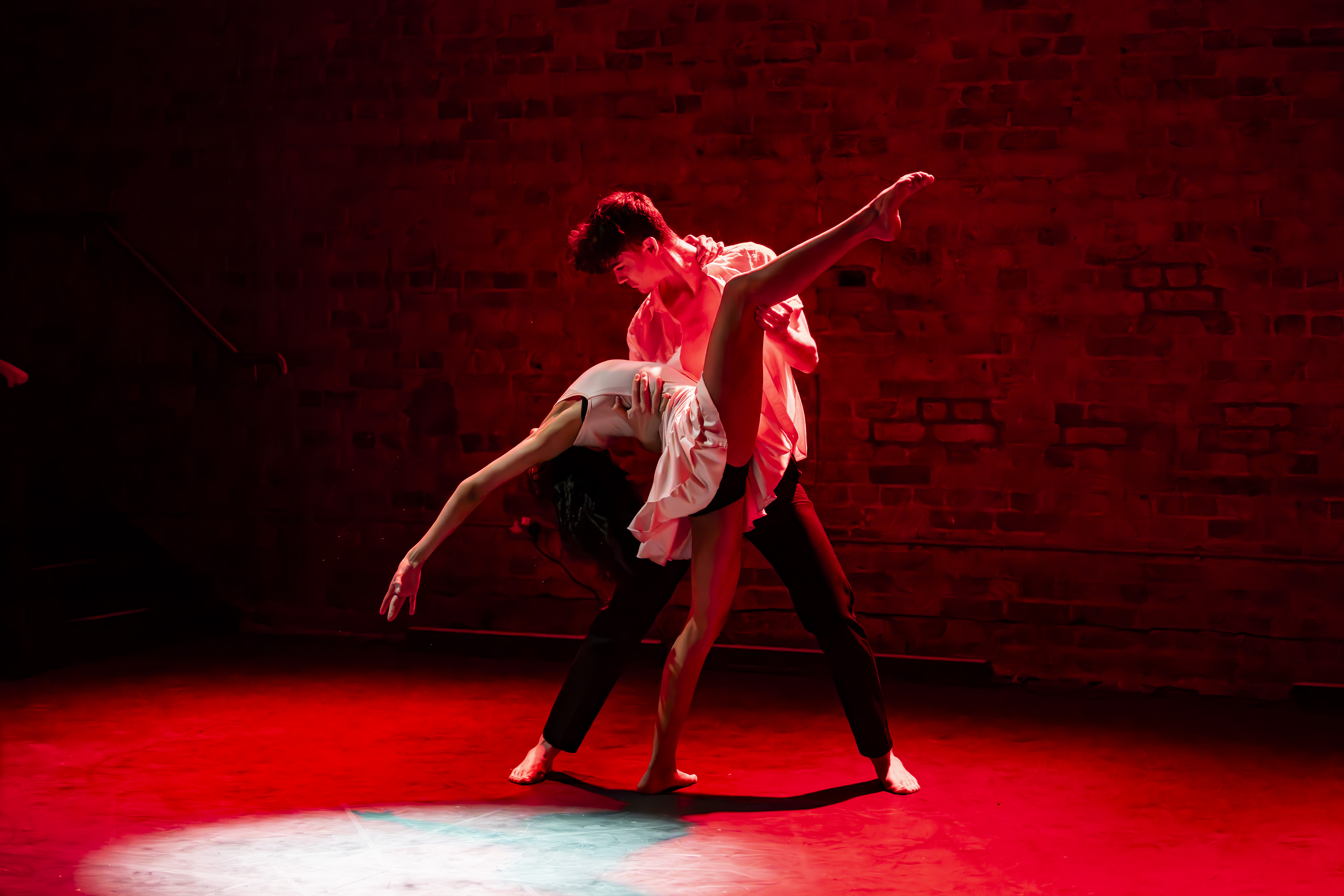 Two dancers in a red spotlight