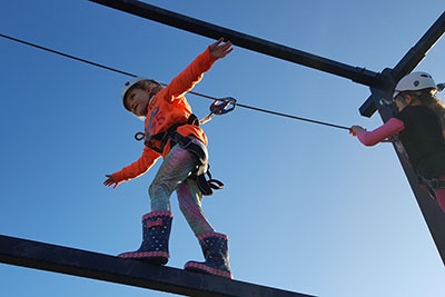 girl climbing on outdoor wire frame