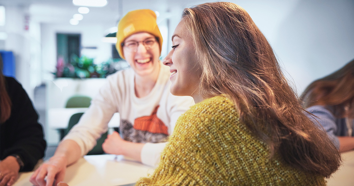 Students sat around a table laughing
