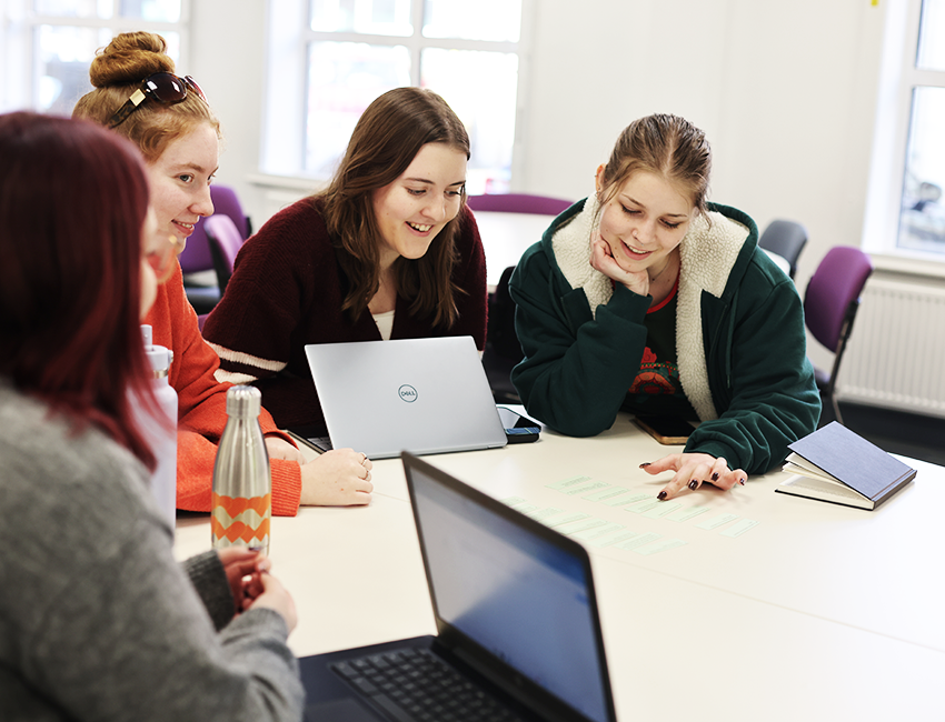 Group of students discussing their work in a classroom