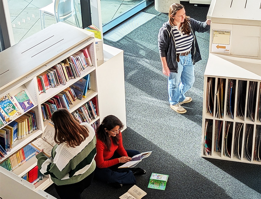 Students looking at picture books in the childrens library