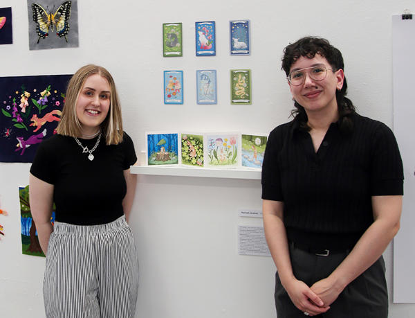 Hannah and Marisa in front of an exhibit at the art exhibition