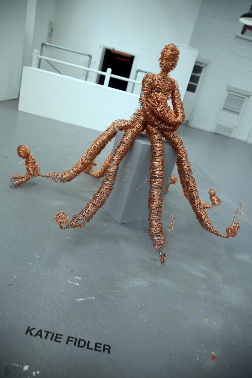 A bronze coloured metal sculpture of a human figure with multiple tentacles
