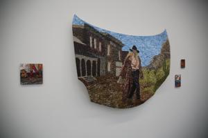 A collage of a man in a hat, created on a full sized car bonnet and hung on the wall