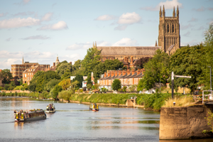 Narrow boats drifting up the River Severn from Diglis Locks with Worcester Cathedral in the background