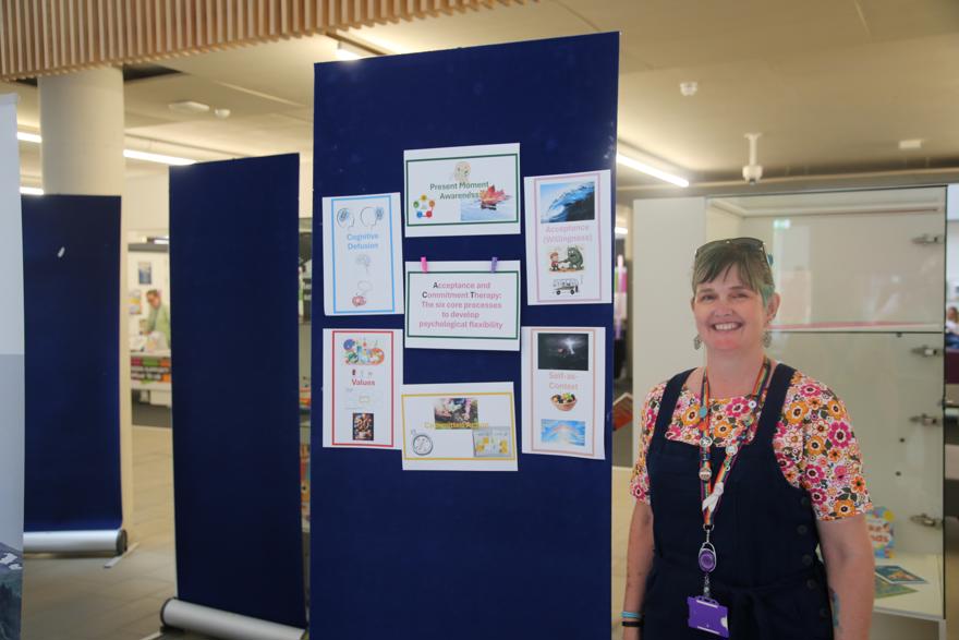 Lecturer Rebecca Weston stands next to her display board