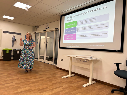 Presenter at the front of a meeting room delivering a talk on Key Changes.