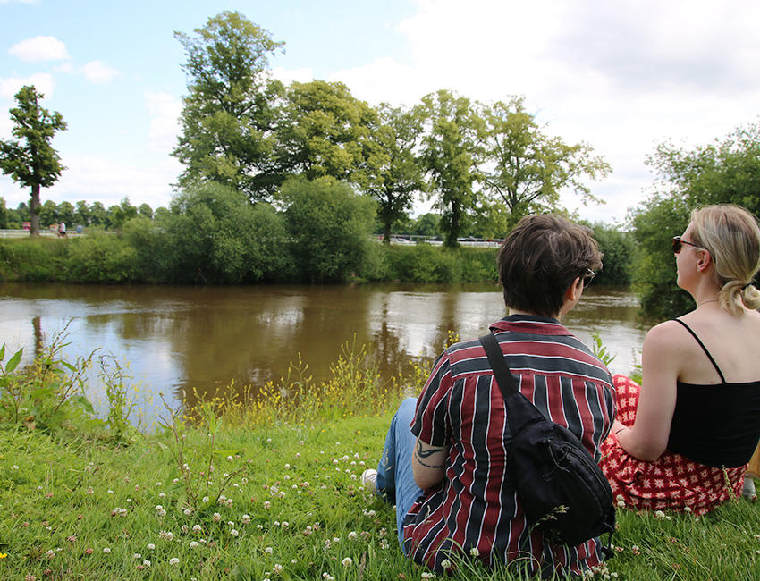 Students relaxing beside the river