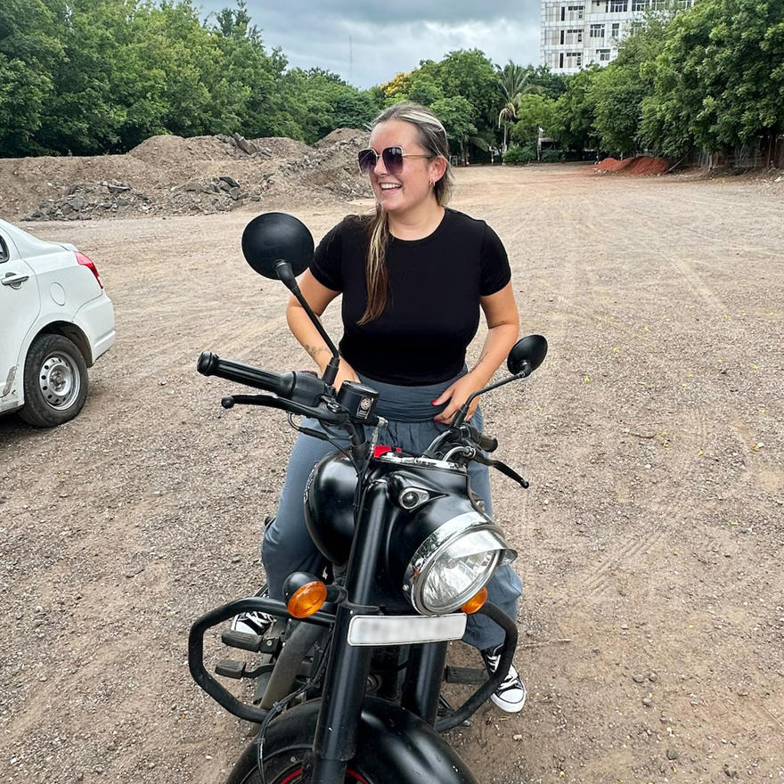 Tea Evans on a motorbike on a road in India