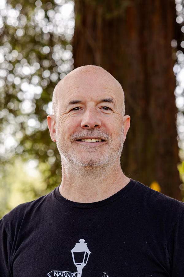 UW Dan Johnson smiles in a portrait shot wearing a black T-Shirt
