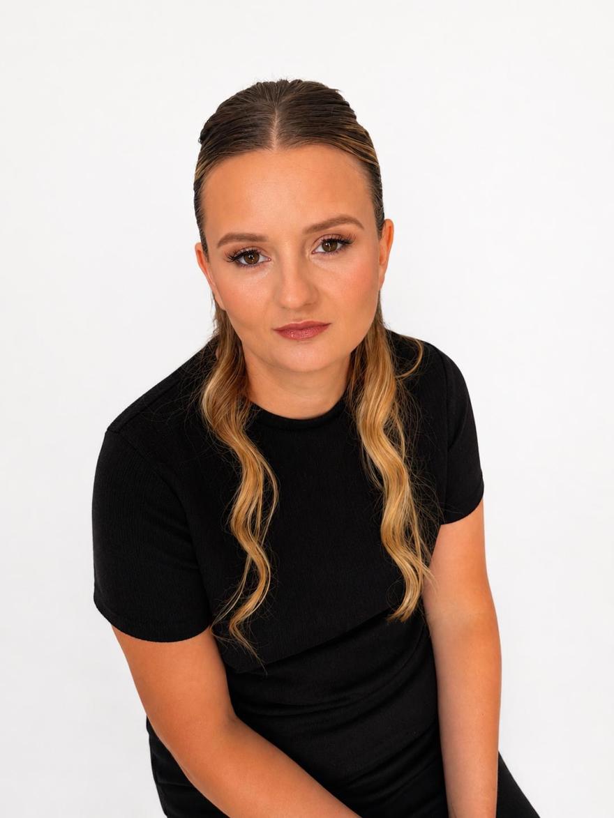 A student poses in black clothing against a white background