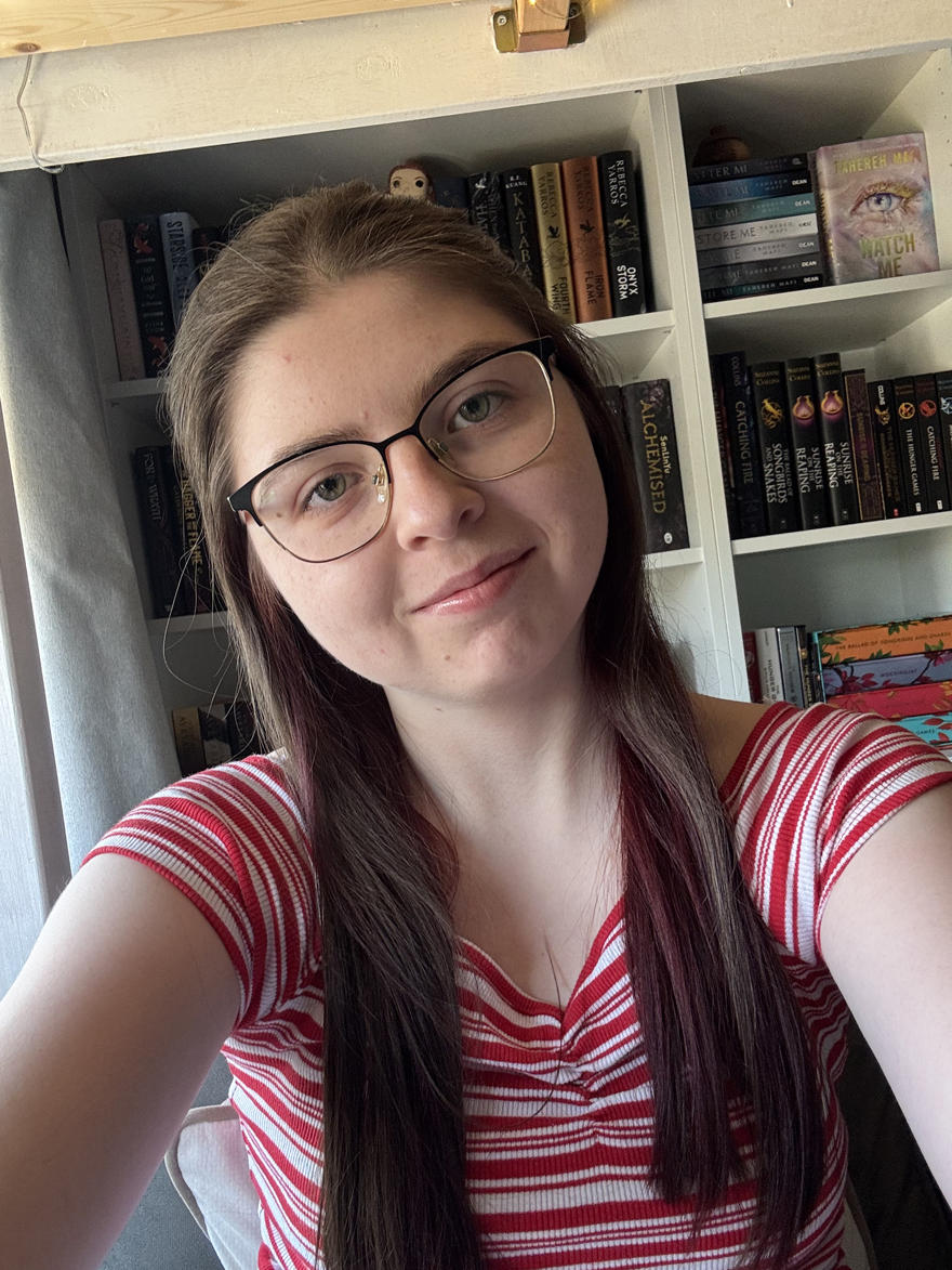 A student with glasses poses for a selfie in a stripey top