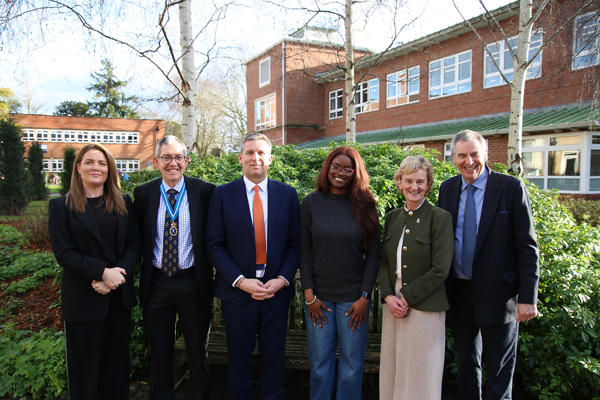 Lord Timpson poses with attendees of the lecture outside a building