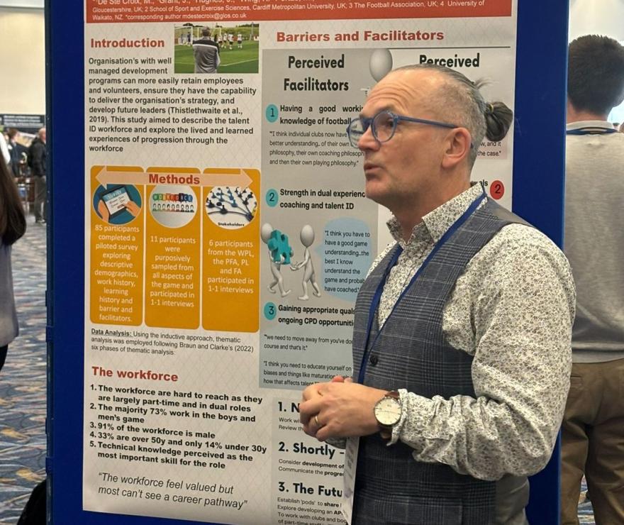 Professor De Ste Croix is pictured in a wastecoat by a board of informaiton