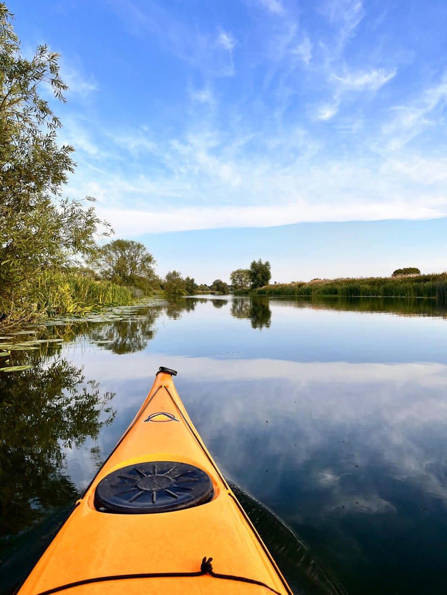 A peaceful river vista, photographed from the cockpit of a kayak