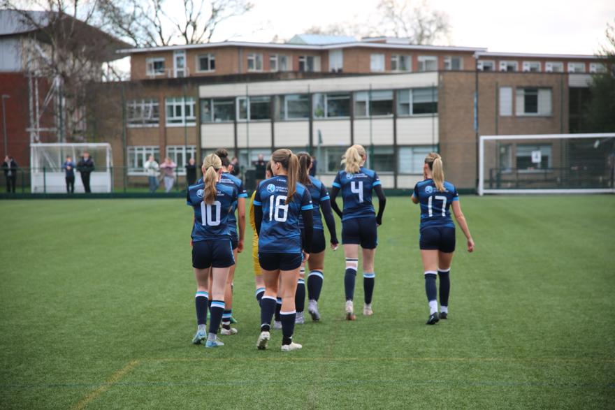 Women's footballers walk away from the camera