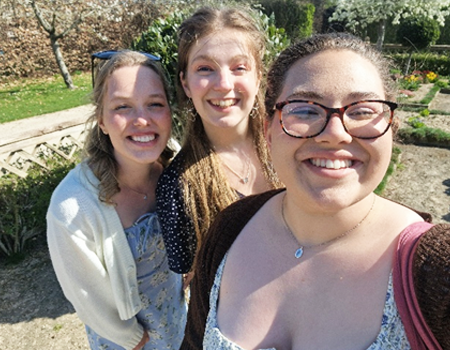 Students taking a group photo together in a sunny garden