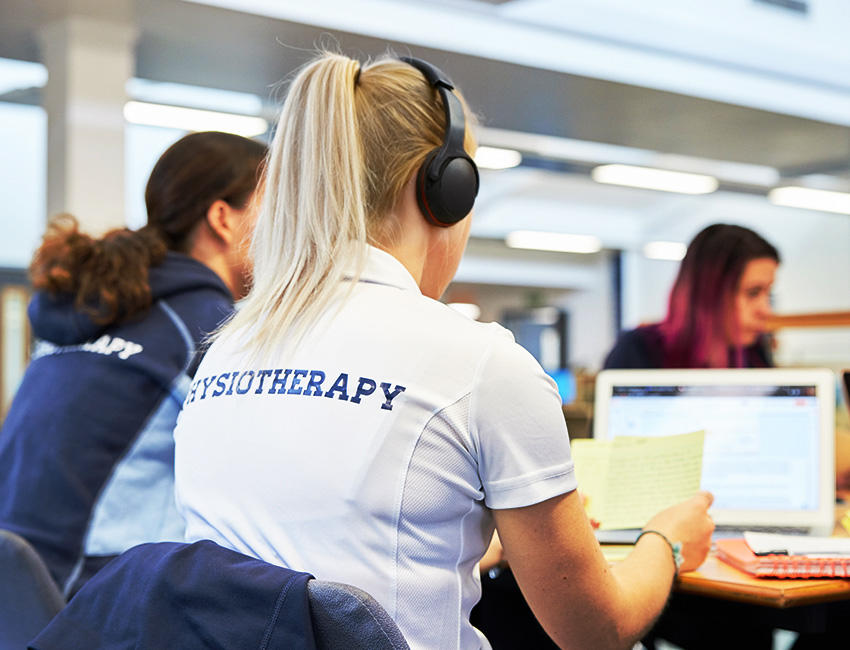 Student studying whilst wearing headphones