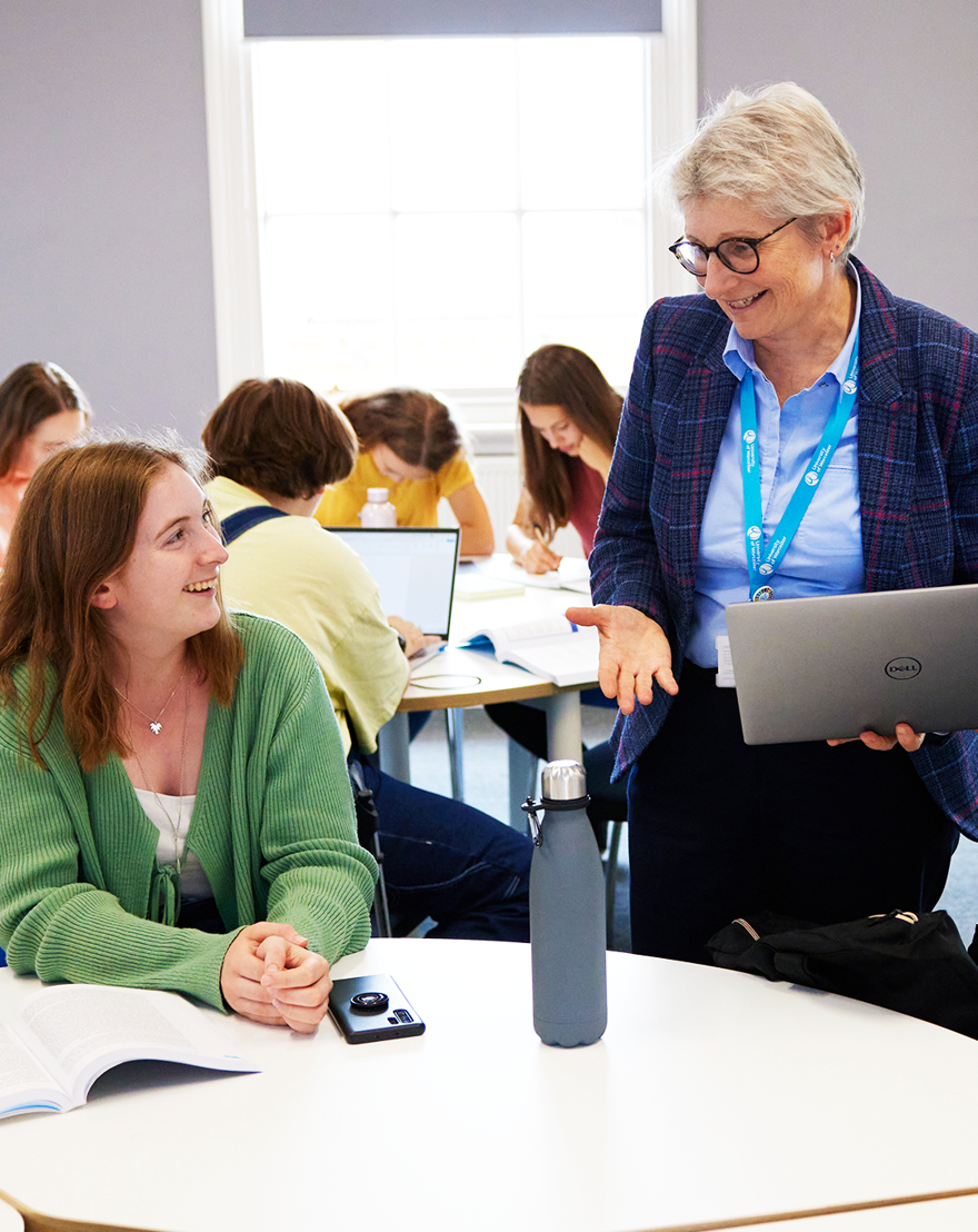Student talking to lecturer in seminar