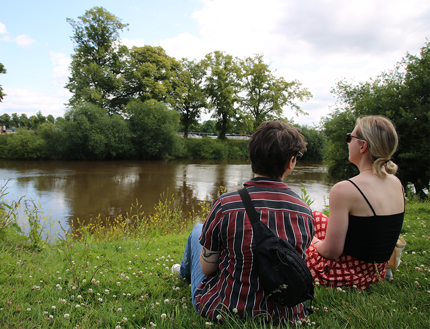 Students sat beside river