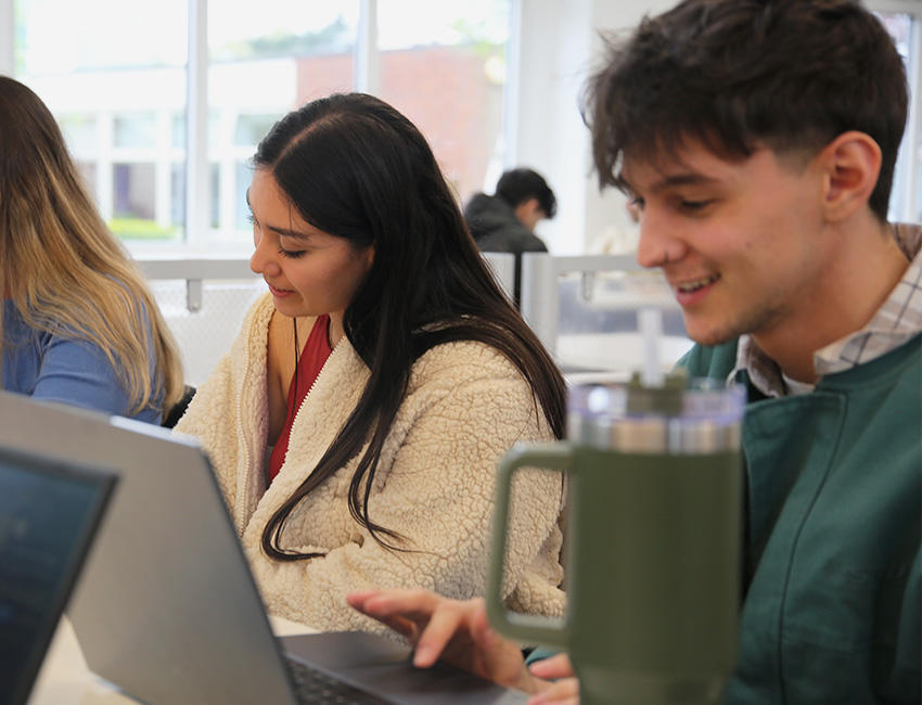 Students working on their laptops smiling