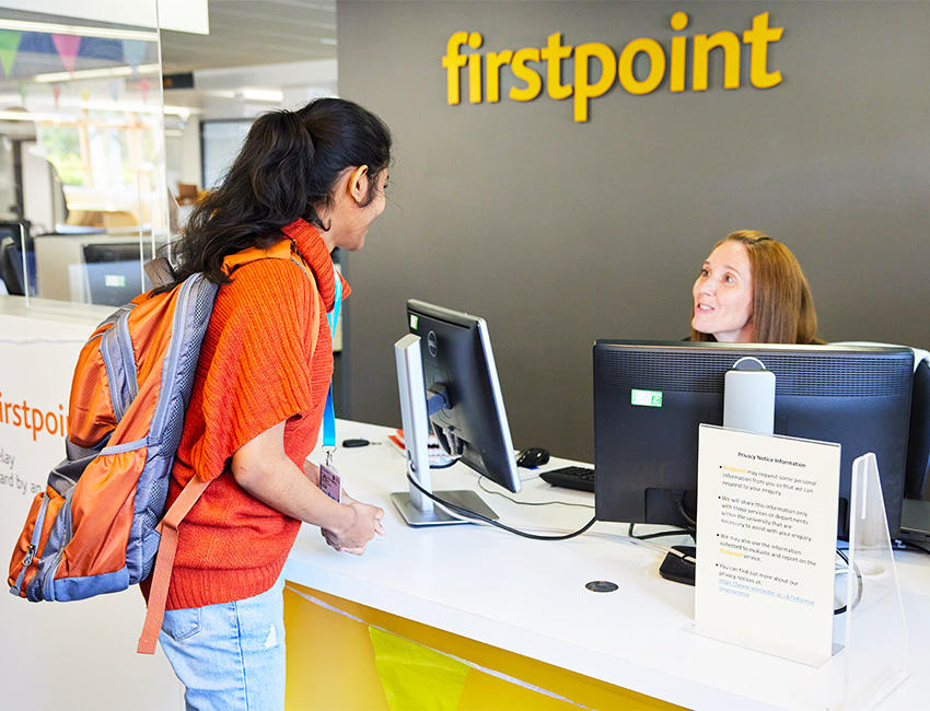 Student speaking to a members of staff at the firstpoint support desk