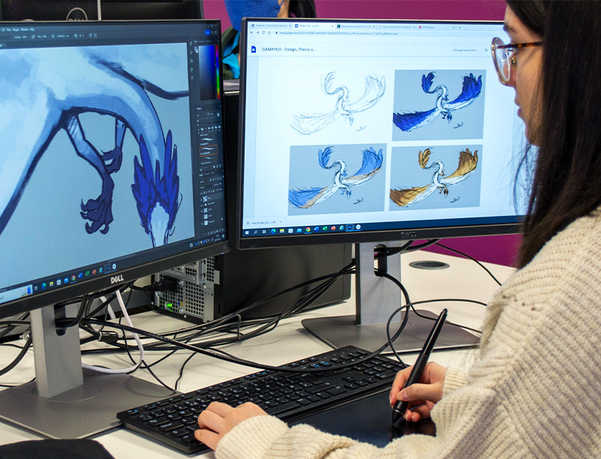 A Game Art student drawing a dragon with a digital sketch pad