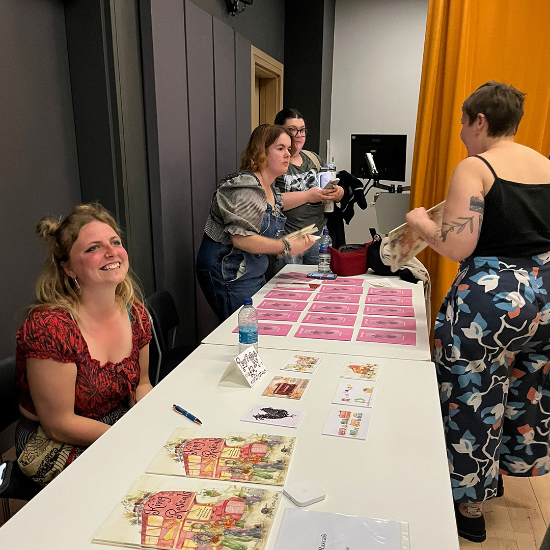 two students selling copies of their books