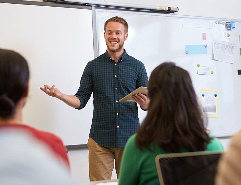 A male teacher is talking animatedly to a class