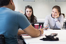 2 female students and 1 male student working at table