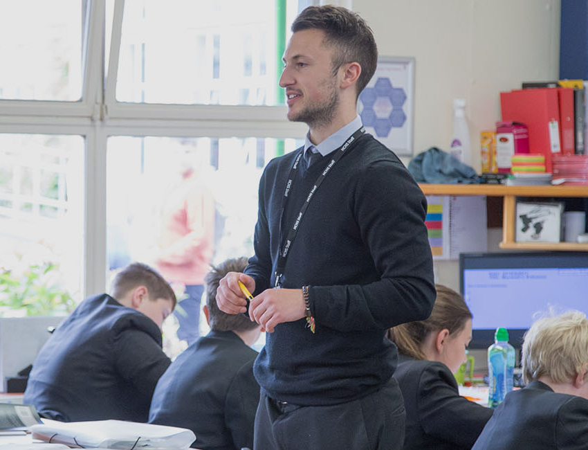 Male teacher standing in secondary classroom