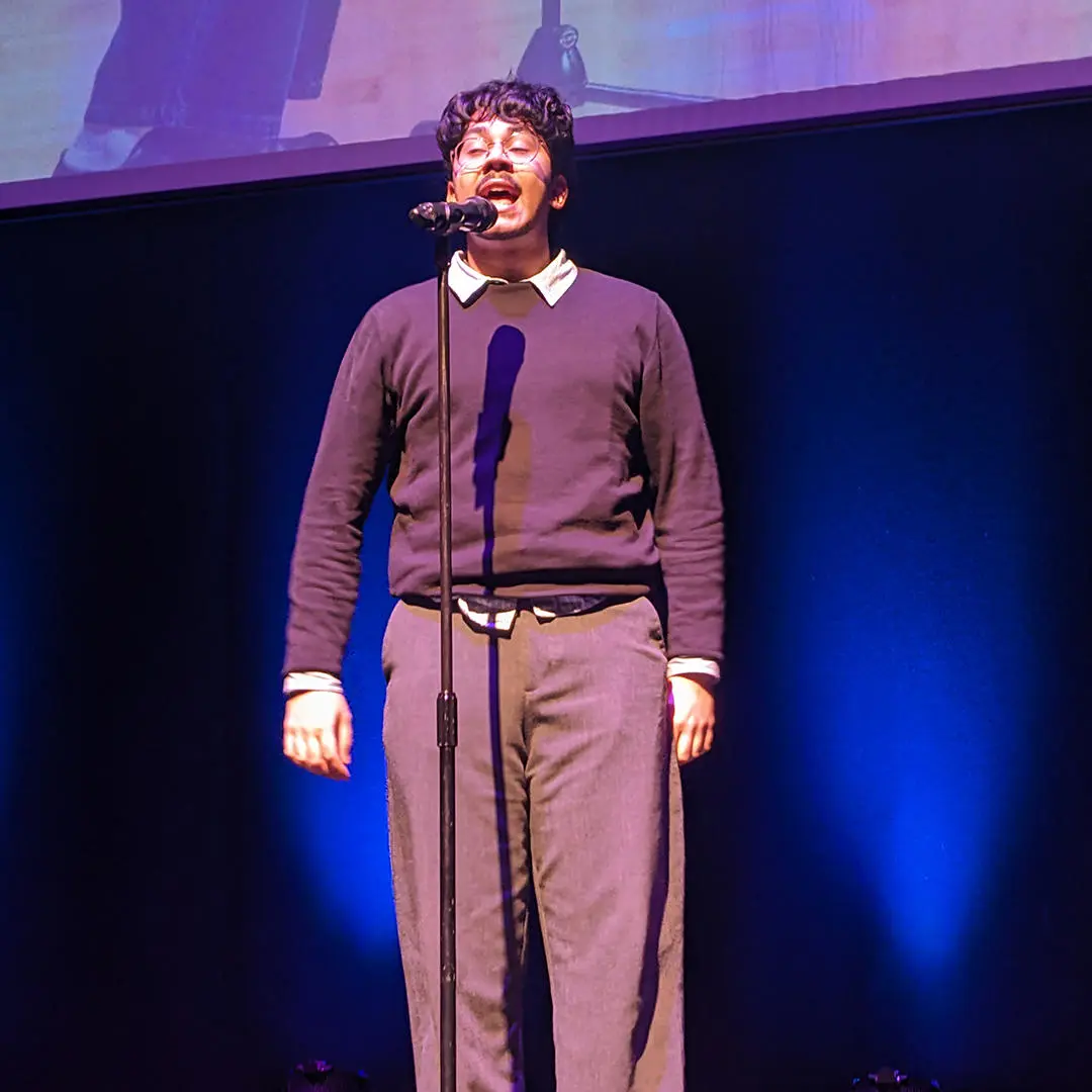 a student talking in front of a microphone