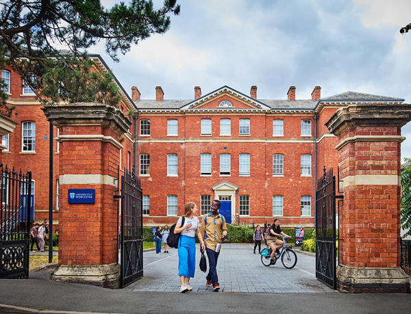 Picturesque brick buildings on City Campus, with students walking through the gates