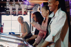 Smiling students are playing on old arcade machines