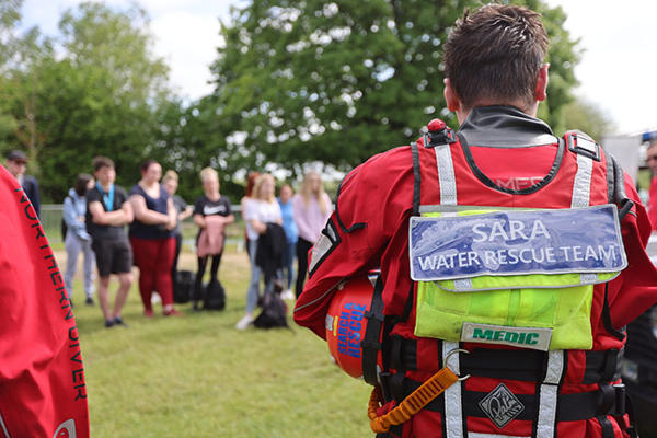 several students are watching a man from a search and rescue team talking