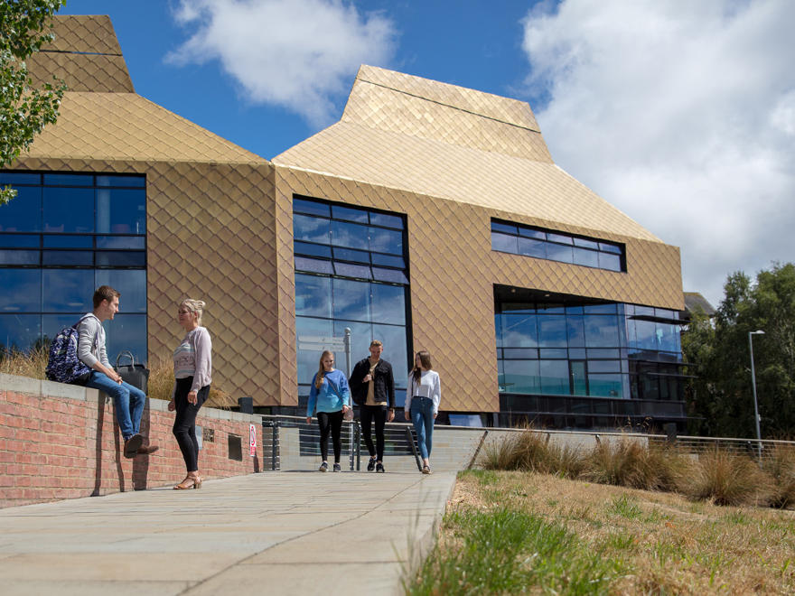 A group of students walking outside of the Hive