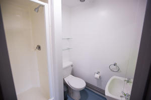 inside a bathroom showing a toilet a sink and a shower