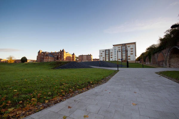 a grey path leading to city campus in the distance