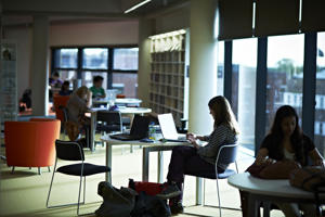 darkened picture of students at desks inside the hive library