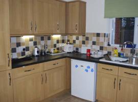 fitted wall cupboards beside a sink and a white fridge