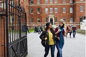 two students walking through the gates at the charles hastings building