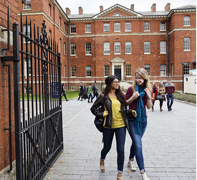 two students walking through the gates at the charles hastings building