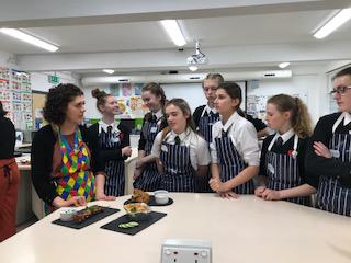 eight pupils and a teacher in a kitchen