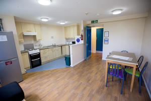inside a communal kitchen including a table and a wooden floor