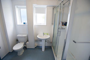 inside a white bathroom with a toilet a sink and a shower