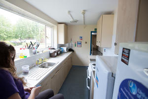inside a narrow kitchen complete with a window a work surface and appliances