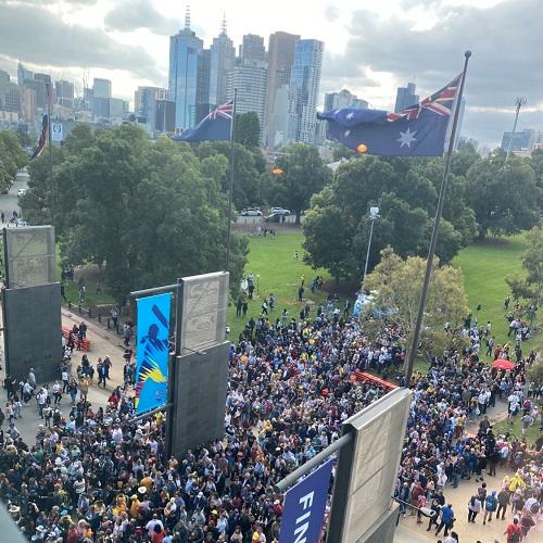 tall buildings in the background and a crowd of people in the foreground