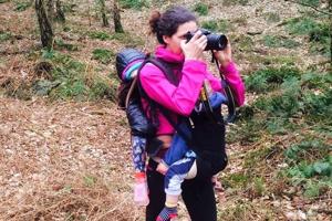 woman in pink top and rucksack holding a camera